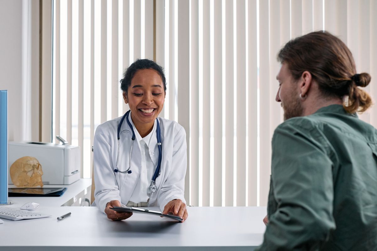 Private Krankenversicherung: Ärztin bespricht Behandlungsoptionen freundlich mit einem Patienten