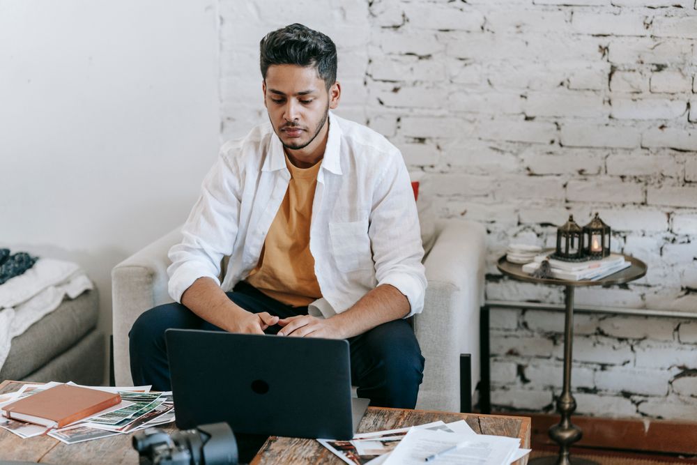 Selbstständiger arbeitet zu Hause am Laptop mit Unterlagen